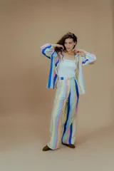 Pantalón de vestir de tiro alto con estampado a rayas verticales de colores pastel y azul. Corte recto con pinzas en la cintura.