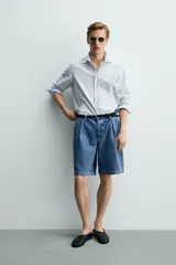 Bermuda de denim de algodón con corte relaxed fit, cintura con pliegues dobles en el delantero, bolsillos laterales y traseros de doble vivo, con efecto lavado y cierre frontal con cremallera y botón.