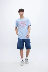 Remera celeste con estampa frontal en color rojo con la frase "UNIFORM ENERGY NO DAYS OFF".