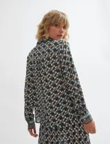 Camisa de manga larga con estampado geométrico en tonos verde inglés, marrón y celeste, cuello camisero y cierre frontal de botones.