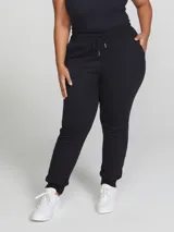Pantalón babucha de algodón color negro, con cintura elástica con cordón ajustable y puños en los tobillos.