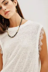 Musculosa blanca de lino con cuello redondo y detalle de encaje en las mangas.