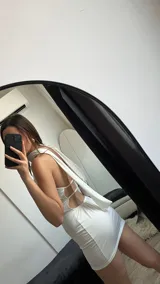 Minivestido blanco de lycra, con escote halter y cuello drapeado.