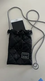 Porta celular negro acolchado con cordón largo a rayas blancas y negras.