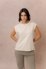Remera de algodón color crema, con cuello redondo y mangas cortas con dobladillo vuelto. Presenta un corte relajado y estructura en los hombros.