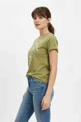 Remera blanca de manga corta y corte holgado, confeccionada en algodón. Presenta un estampado frontal de estilo vintage con una mariposa azul, flores y la inscripción "Find your peace of mind, free your spirit".