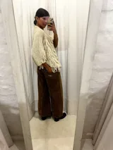 Jean de corte oxford con tiro medio-alto, confeccionado en algodón. Presenta un diseño de paneles con cortes verticales en dos tonos de azul y costuras marcadas en las piernas, ofreciendo una silueta amplia y fluida.