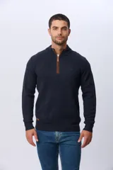 Buzo tejido de punto con textura en relieve, color azul marino. Presenta cuello alto con cierre frontal parcial y detalles en gamuza en la zona del cierre. Posee puños y ruedo acanalados.