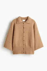 Cárdigan de punto suave color camel, con cuello camisero y cierre frontal de botones. Presenta hombros caídos y mangas amplias de corte tres cuartos. El bajo es de punto acanalado.