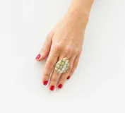 Anillo con diseño de mosaico en tonos verdes y crema, elaborado en resina italiana de alta calidad con base de acero dorado ajustable.