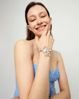 Pulsera rígida plateada con detalle de ojo.