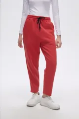 Pantalón tipo babucha de corte recto, confeccionado en tejido con felpa, con cintura elástica y cordón de ajuste frontal.