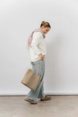 Cartera tipo tote de diseño amplio y estructurado, confeccionada en material sintético con textura graneada. Cuenta con doble asa larga para llevar al hombro y logo de la marca aplicado en el frente.