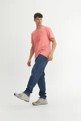 Remera de algodón color coral con cuello redondo, mangas cortas y estampa frontal con el texto 'SOLID CREW' y un diseño gráfico de un volcán en tonos naranja.