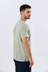 Remera básica de manga corta y cuello redondo, color bordó, con cartera de botones en el pecho y pequeño bordado al tono.
