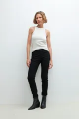 Pantalón de denim negro, corte slim, con cintura media y cierre frontal con botón y cremallera.