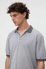 Remera polo de manga corta color rojo con efecto lavado, cuello y puños en contraste marrón. Cuenta con media cartera de botones, aberturas laterales en el dobladillo y un bordado pequeño de una estrella en el pecho.