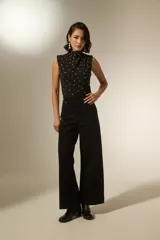 Pantalon de jean negro de corte ancho y tiro alto, con costuras verticales frontales y bolsillos laterales.