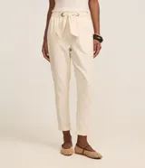 Pantalón carrot de sarga color crudo, con cintura elástica, lazo ajustable y bolsillos laterales.