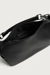 Bandolera negra de acabado liso, con compartimento principal con cierre de cremallera, bolsillos laterales planos y un bolsillo interior con cremallera. Incluye asa de mano extraíble y asa de hombro ajustable y extraíble.