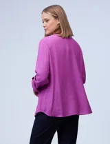 Blusa texturada color violeta, marca Ruby Rd. Tiene cuello a la base con escote en V y mangas largas con largo regulable.