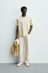 Camiseta regular fit de color beige, confeccionada en tejido de algodón compacto, con cuello redondo y manga corta.