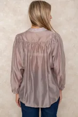 Camisa de organza blanca con cuello mao, diseño de manga larga tipo murciélago y cierre frontal con botones. Presenta un corte holgado y fluido.