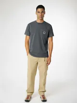 Camiseta gris de manga corta con efecto lavado, cuello redondo y un bolsillo en el pecho con detalle de parche estampado.