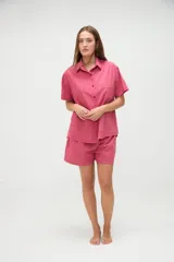 Camisa de manga corta con calce holgado, cuello camisero, cierre frontal de botones y un bolsillo aplicado en el pecho. Presenta diseño de rayas verticales.