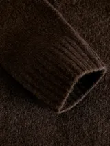 Sweater de punto color beige, con cuello polo y cierre frontal de tres botones, mangas largas con puños acanalados y diseño clásico.