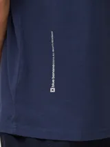 Camiseta de corte regular fit color azul marino, de manga corta y cuello redondo, confeccionada en 100% algodón orgánico, con un pequeño estampado de una cruz blanca en el pecho.