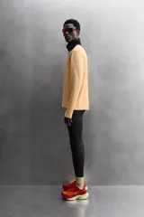 Camiseta deportiva color durazno de manga larga con orificios para los pulgares.