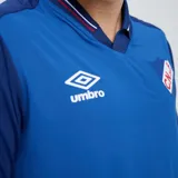 Remera polo de fútbol Umbro del Club Nacional de Football, color azul con cuello en V y detalles en rojo y blanco.