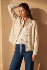 Sobrecamisa de algodón color crudo, con corte oversize, cierre frontal de botones y detalle de bordado broderie en el ruedo.