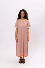 Vestido largo tipo remerón de manga corta color rosa, con cuello redondo y ruedo con ribete naranja.