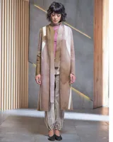 Tapado largo de lana merino afieltrada, color fucsia con diseño tie-dye artesanal en tonos claros y crudos. Tiene cuello que se prolonga a modo de cinto, aberturas laterales y bolsillos.