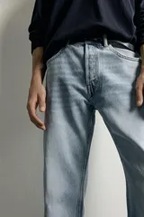 Jeans regular fit confeccionados en denim de algodón celeste con efecto lavado, de cinco bolsillos y cierre frontal con cremallera y botón.