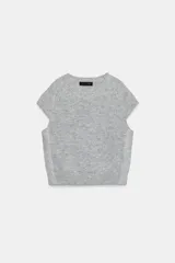 Jersey de punto gris jaspeado con cuello redondo y manga corta. Presenta detalles de encaje en los laterales.