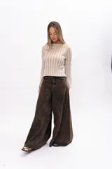 Buzo de punto al cuerpo con diseño de rayas verticales en relieve, cuello redondo y mangas largas con terminación acampanada.