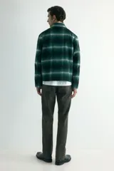 Sobrecamisa de lana con acabado cepillado, diseño a cuadros en tonos verde oscuro, negro y blanco. Cuenta con cuello inglés, cierre bidireccional frontal y bolsillos laterales discretos. Forrada y de corte regular.