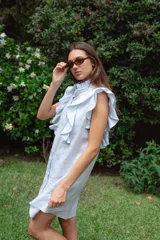 Vestido corto color verde oliva de lino con cuello mao fruncido, volados en los hombros, caída recta y botones al frente.