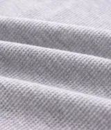 Bata de baño larga de tejido de poliéster texturizado con relieve, cuello estilo chal, mangas largas, bolsillos frontales y lazo para ajustar en la cintura.