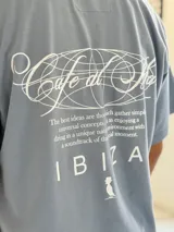 Remera oversize color beige, con mangas corta y gran estampado gráfico en la espalda con texto en negro.