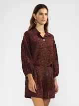 Camisa marrón con estampado animal print, cuello camisero, manga larga abullonada con puños elastizados y lazos regulables en los costados del ruedo.