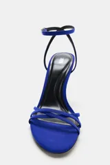 Sandalia de tacón alto fino color azul, con tiras delanteras cruzadas y cierre de hebilla en la pulsera del tobillo.