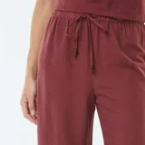 Pantalón ancho de tiro alto, color rojo oscuro o bordó, con cordón ajustable en la cintura.