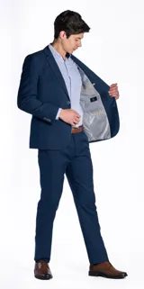 Ambo de vestir para hombre en color azul marino, compuesto por saco de botonadura simple con solapas de muesca, bolsillos con solapa y pañuelo decorativo en el bolsillo superior, acompañado de pantalón de corte recto y formal.