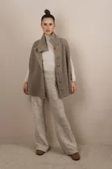 Capa color beige con textura de espiga, cuello alto con botones y aberturas laterales para los brazos. Confeccionada en lana fina sin teñir.