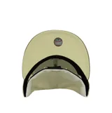 Gorra New Era modelo 59Fifty con visera plana, color crema con visera y logo bordado en color caqui. Presenta estructura cerrada y logo de la marca bordado en el lateral.