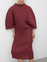 Vestido midi de poliéster reciclado con textura plisada, cuello perkins y mangas amplias redondeadas. Presenta un diseño de corte holgado con un detalle de cambio de textura en el lateral izquierdo.